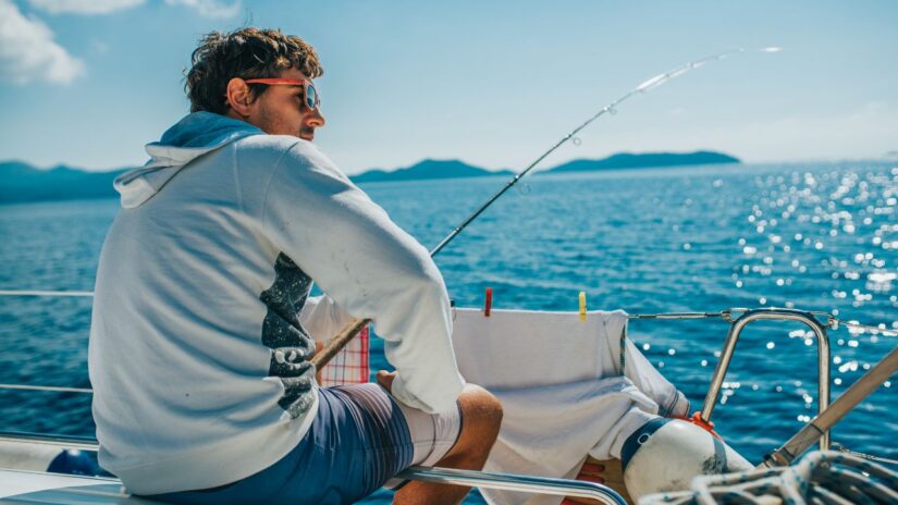 Guy fishing on a boat